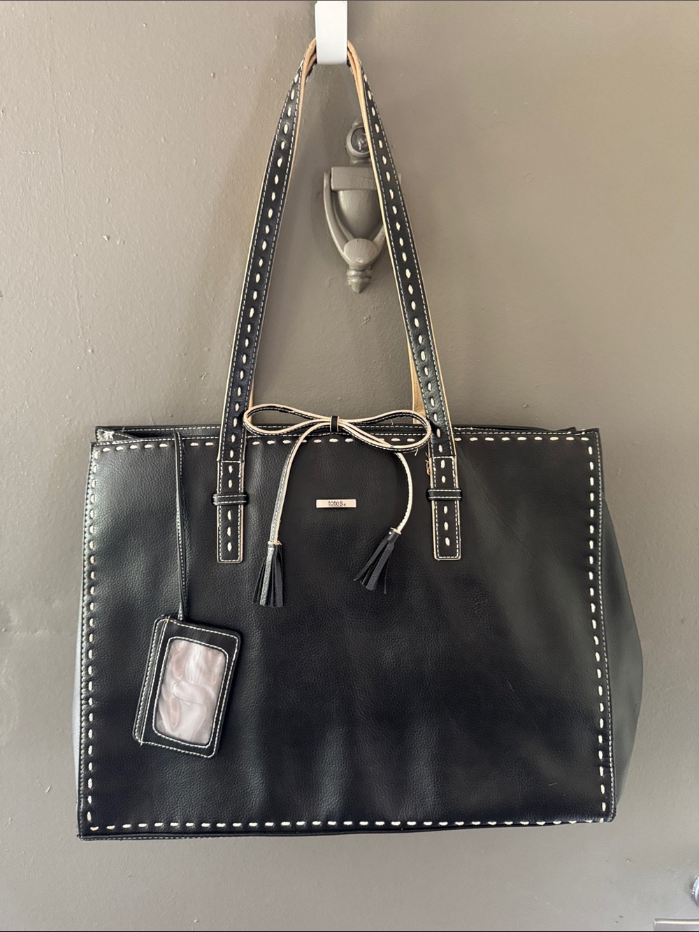 Totes Black Tote Travel Handbag with Contrast Stitching and Bow n’ Tassel Accent